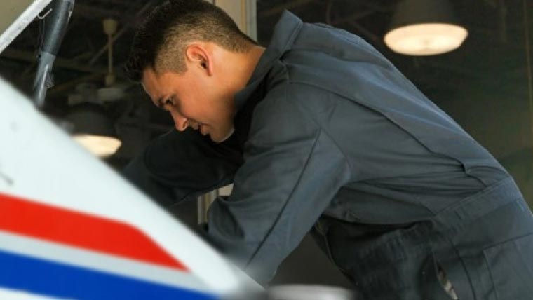 USPS Automotive technician checking a tire of a truck